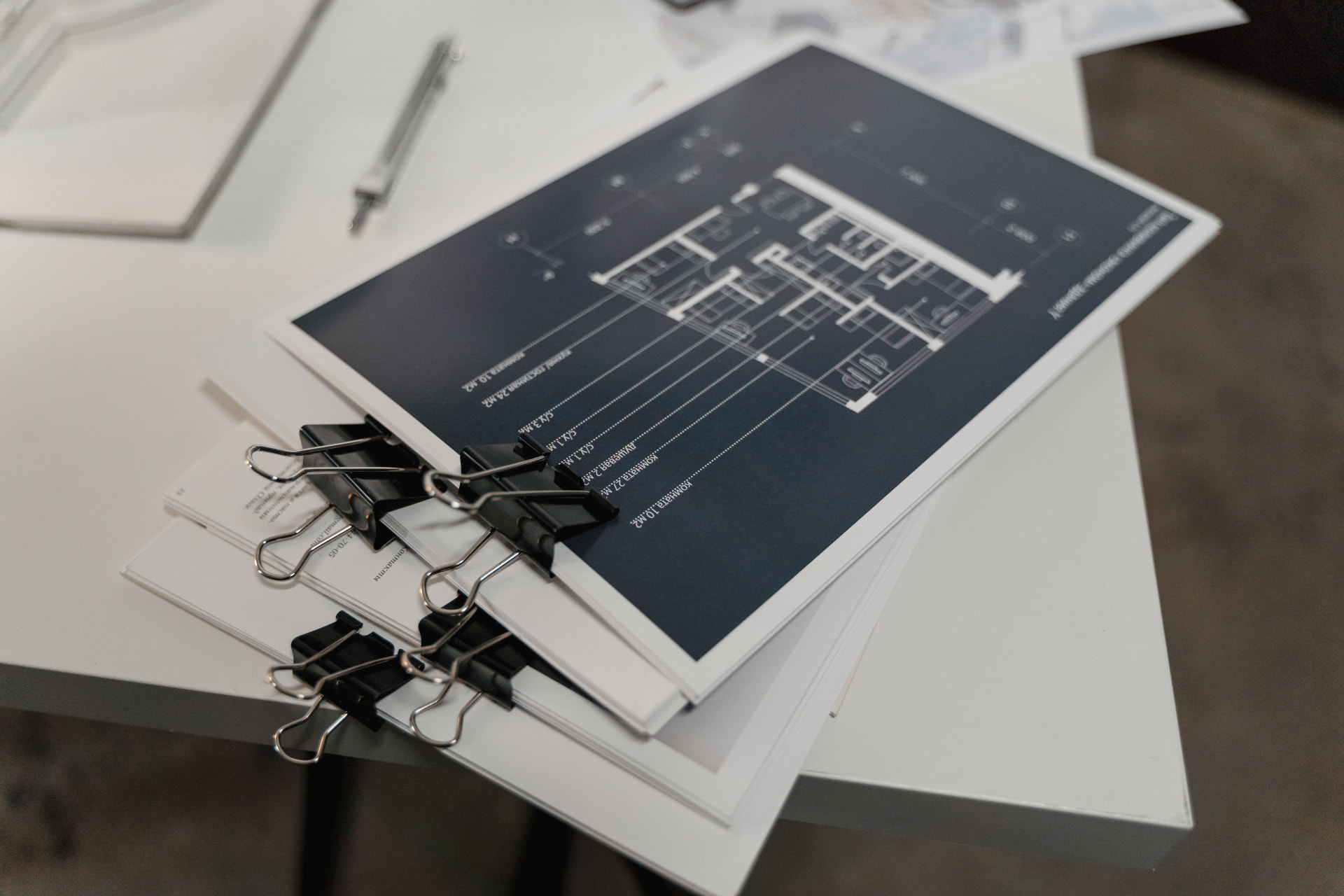 Stack of steel fabrication shop drawings clipped together on a workshop desk