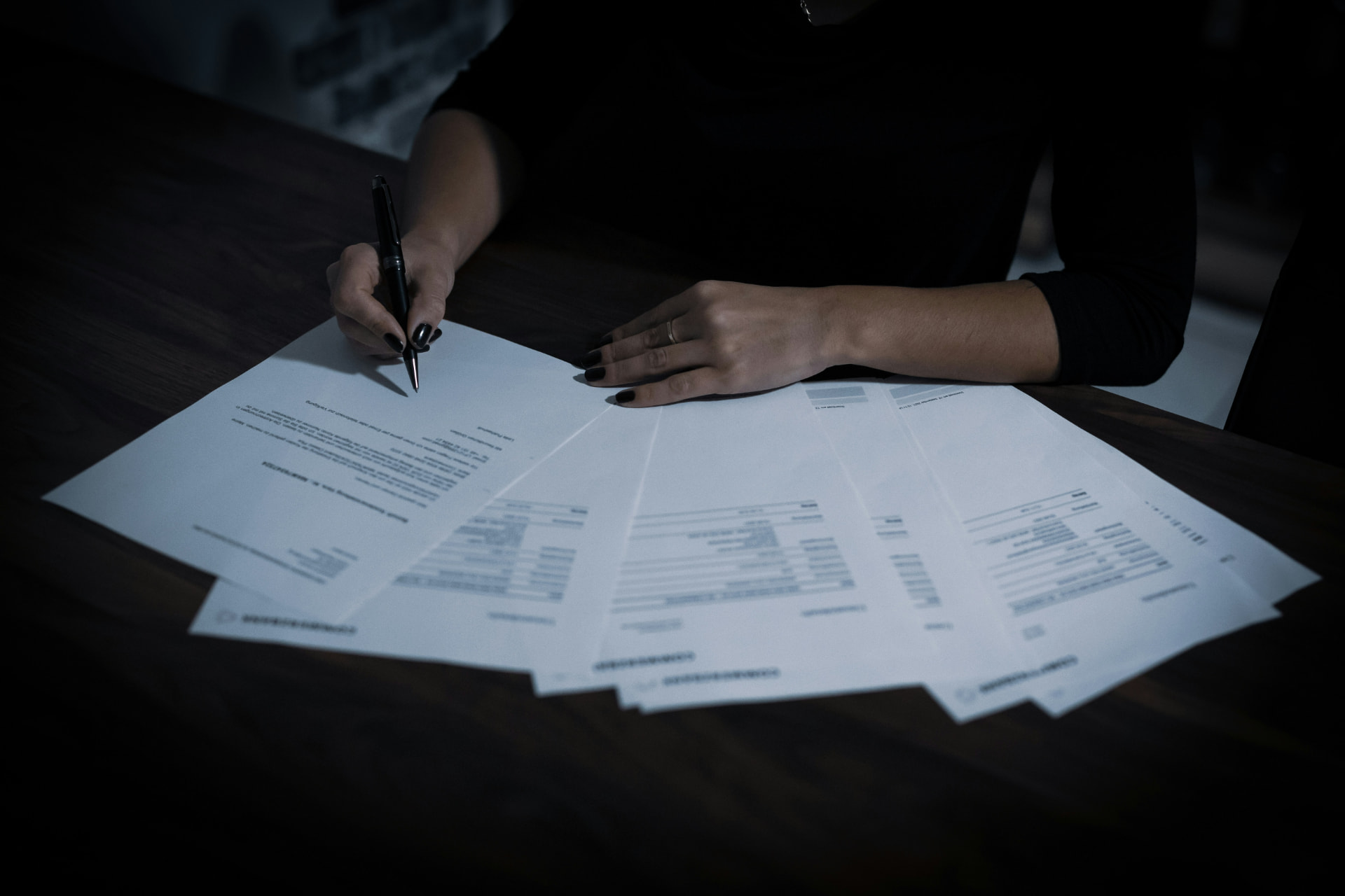 Contract documents spread across a desk being signed