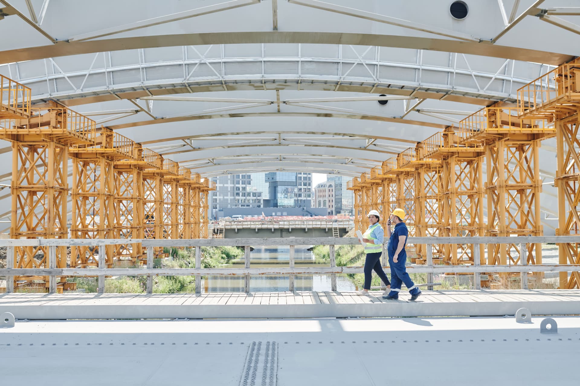 Site supervisor and steel installer walking a structural steel deck on a live construction site